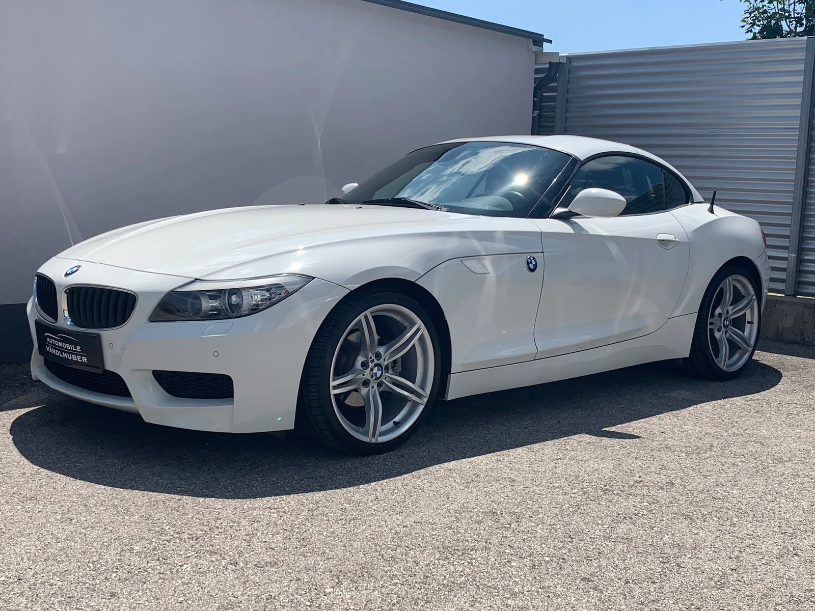 Weißer BMW Z4 vor einer hellen Hallenwand